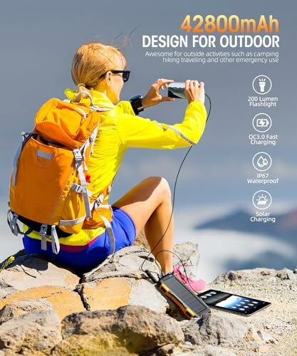 Person using a solar-powered device outdoors with a backpack.